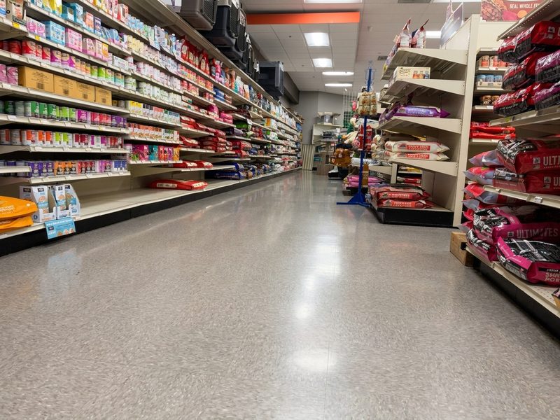 A long aisle of food bags and cans stretching to the back of the store