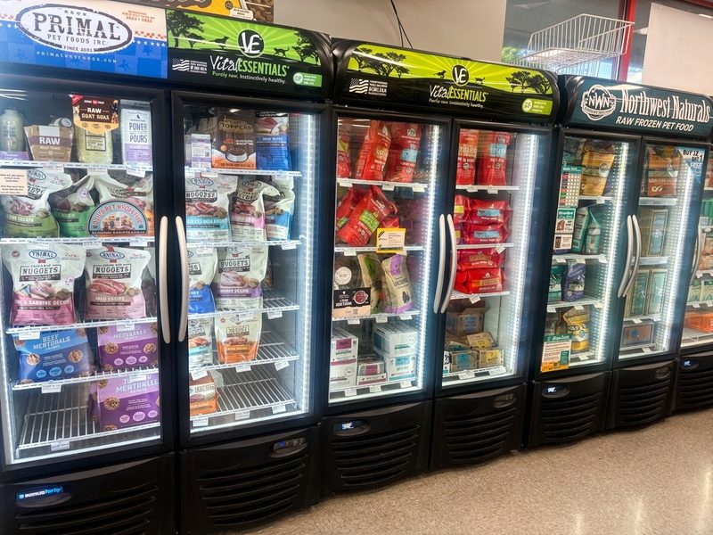 A row of freezers stocked with Primal, Vital Essentials and Northwest Naturals raw food