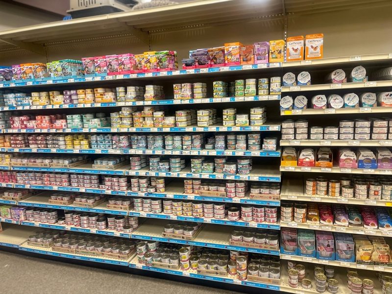 A long wall of canned and wet cat food